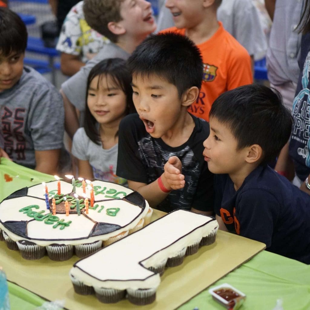 Joyful birthday party celebration with Strong Fitness featuring a delicious cake.